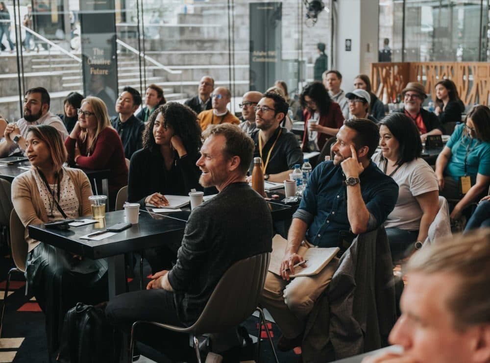 A full room of attendees at a corporate event.