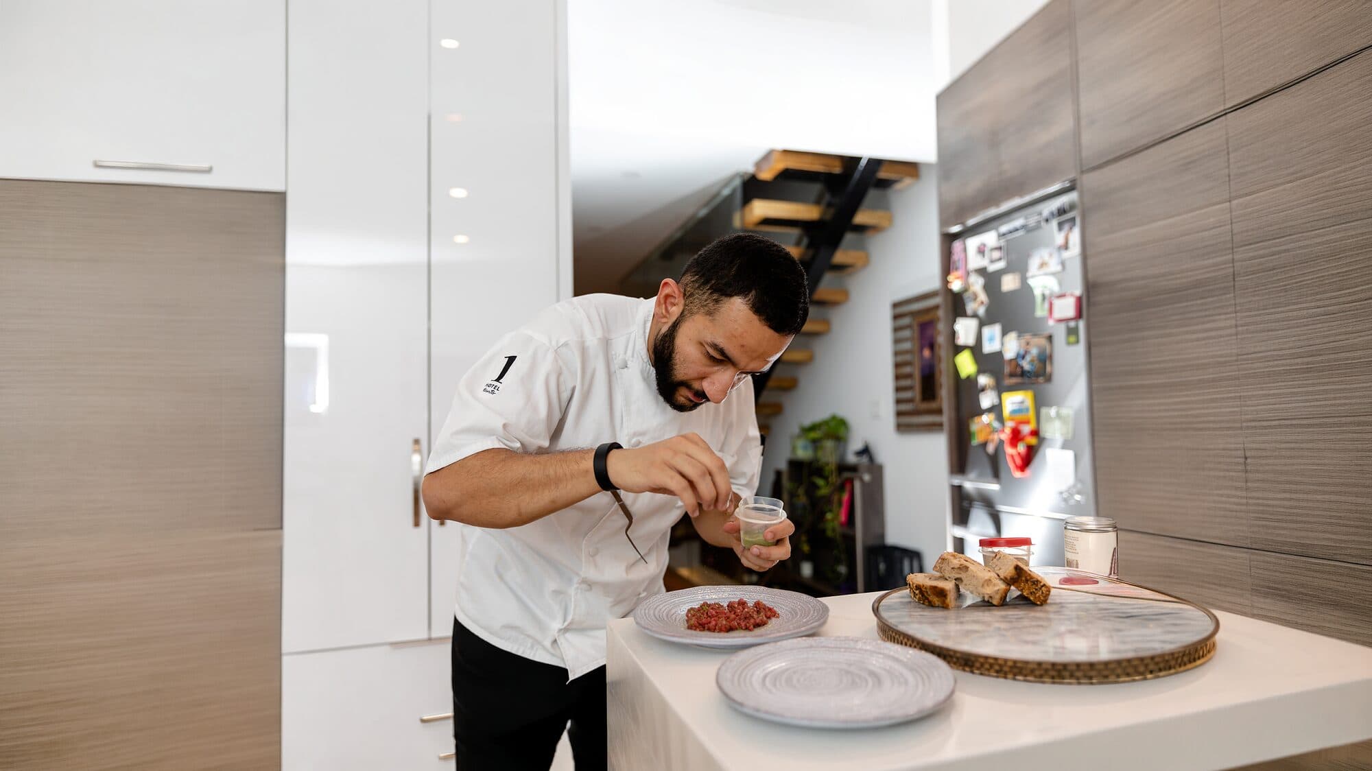 A chef finishing a plated dish during a Studio development session.