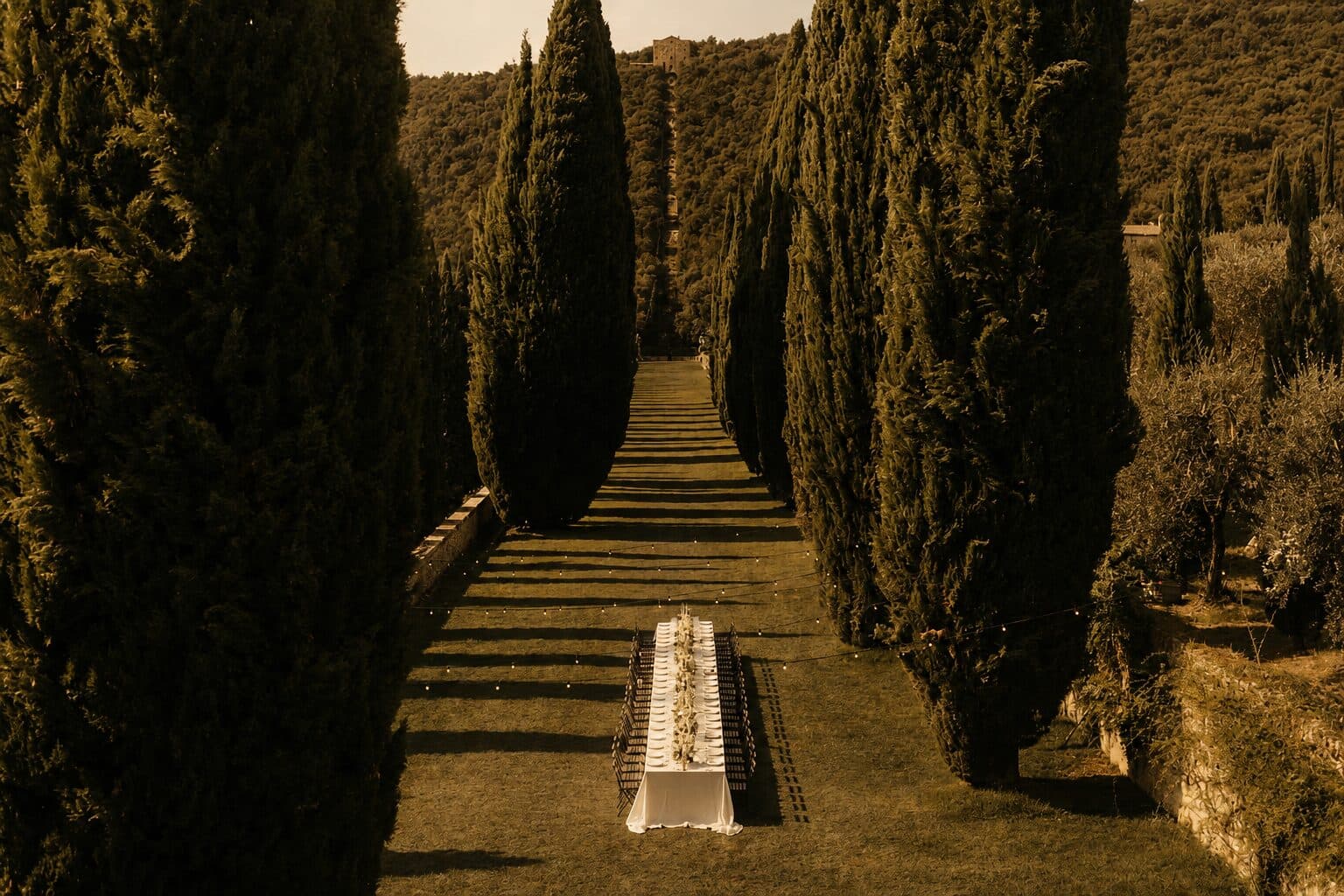 A long outdoor dining table set for a NOR Table service at dusk.
